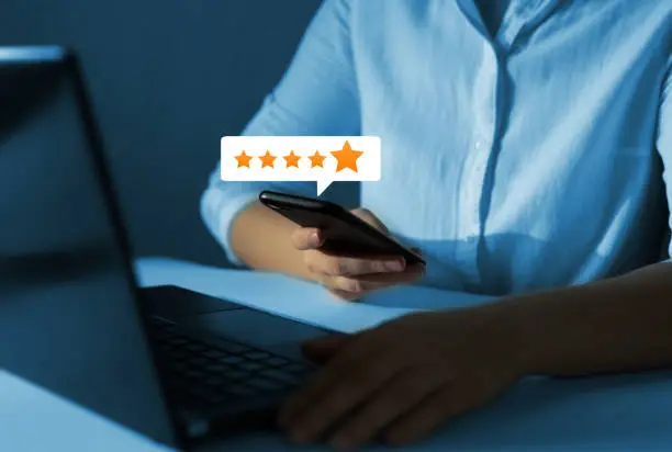 Woman who gives leave feedback on the bought product with gold five star rating feedback icon. Concept of satisfaction, quality and performance of services