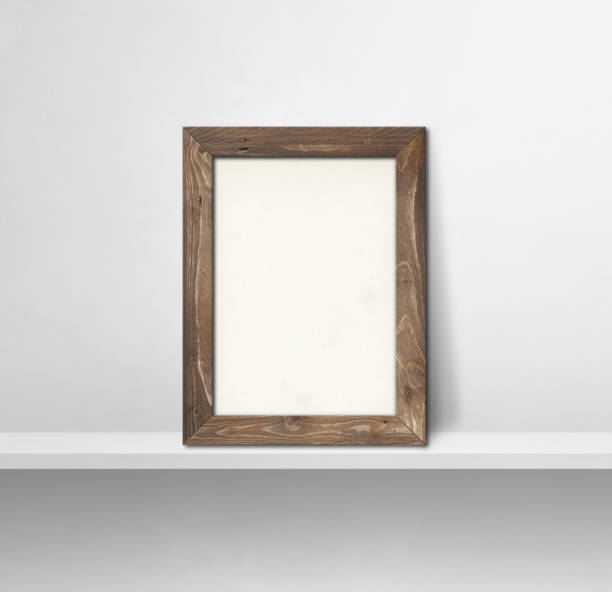 istock Wooden picture frame leaning on a white shelf. 3d illustration. Square background 1352821687