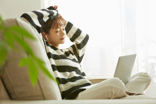 A young Asian woman working on her computer at home