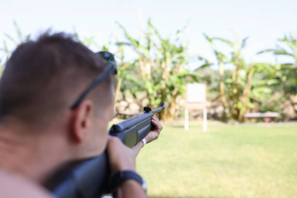 Man shooting gun at target on vacation closeup. Shooting training concept