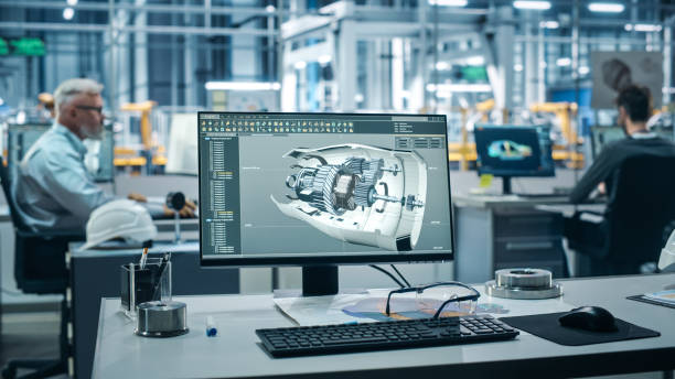istock Car Factory Office: On the Desk Computer with Turbine Prototype, Design Advanced 3D Model for High-Tech Green Energy Electric Engine. Automated Robot Arm Assembly Line Manufacturing Facility 1352825073