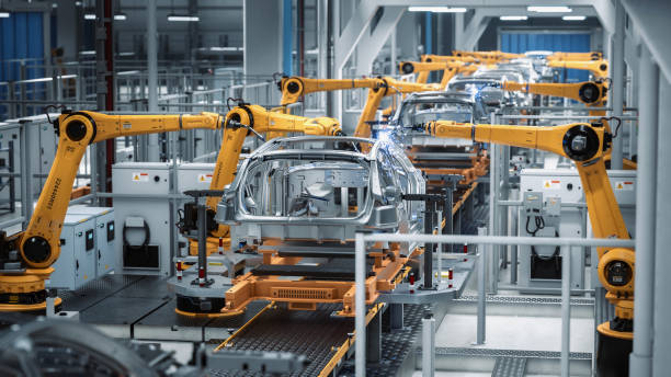 istock Car Factory 3D Concept: Automated Robot Arm Assembly Line Manufacturing Advanced High-Tech Green Energy Electric Vehicles. Construction, Building, Welding Industrial Production Conveyor. Back View 1352825175