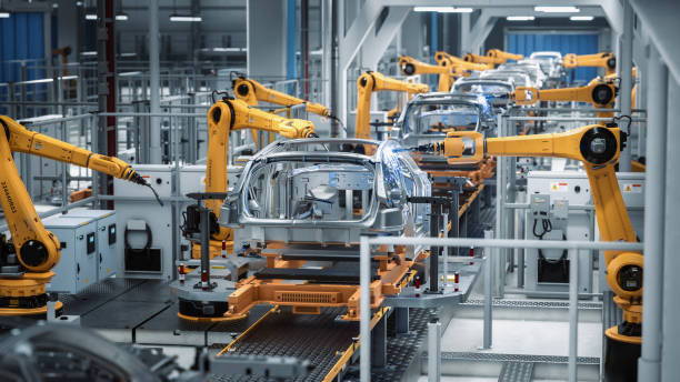 istock Car Factory 3D Concept: Automated Robot Arm Assembly Line Manufacturing Advanced High-Tech Green Energy Electric Vehicles. Construction, Building, Welding Industrial Production Conveyor. Back View 1352825176