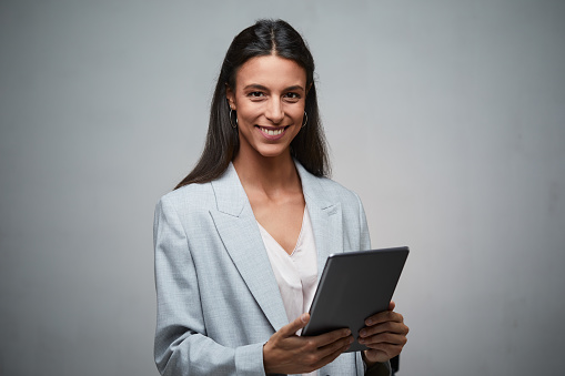 Studio shot of a young businesswoman holding a digital tablet.
