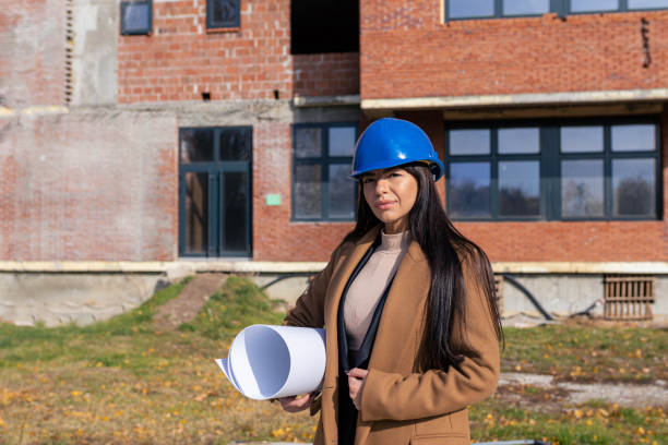 istock Modern female architect standing in front of the building in construction 1352825866