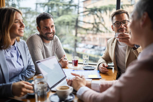 istock Happy business colleagues talking in a cafe. 1352826646