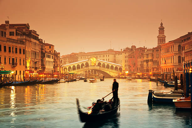 Rialto Bridge, Venice - Italy Rialto Bridge and gondolas at a foggy autumn evening in Venice. grand canal venice stock pictures, royalty-free photos & images