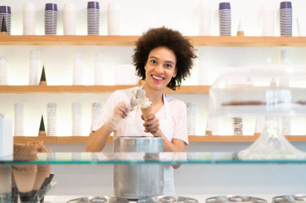 istock Happy woman working at an ice cream parlor 1352828384