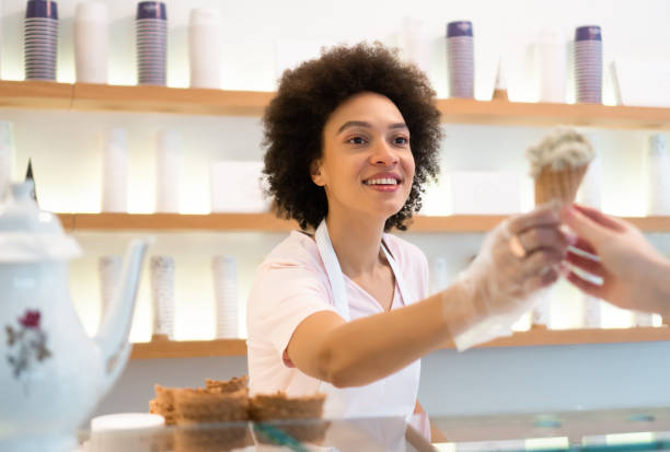 istock Happy woman working at an ice cream parlor 1352828926