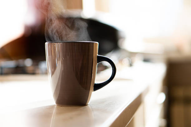 istock Brown coffee cup on kitchen table with real natural daylight and steam 1352829234