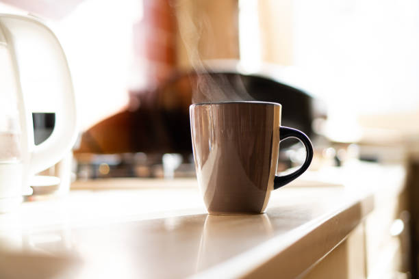 istock Brown coffee cup on kitchen table with real natural daylight and steam 1352829255