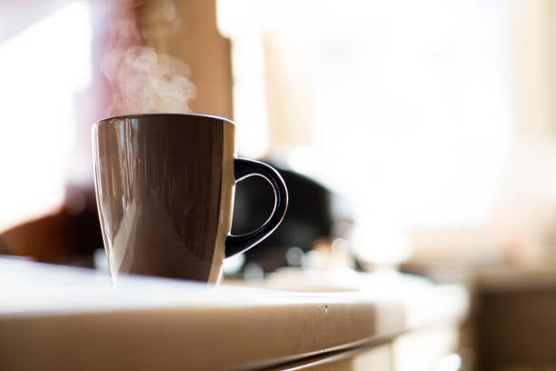 istock Brown coffee cup on kitchen table with real natural daylight and steam 1352829501