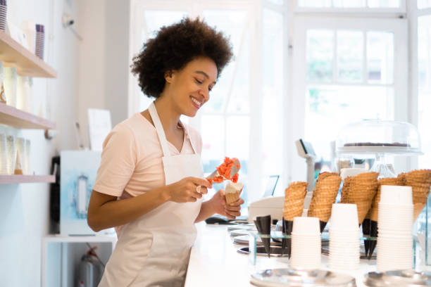 istock Happy woman working at an ice cream parlor 1352829757
