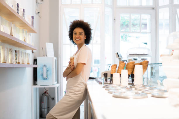 femme heureuse travaillant dans un glacier - ice cream parlor photos et images de collection