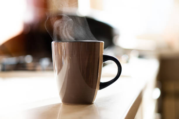 istock Brown coffee cup on kitchen table with real natural daylight and steam 1352830483