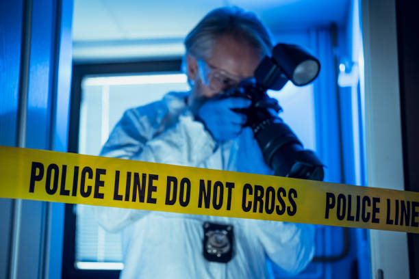 Forensic scientist working at crime scene Senior forensic scientist doing photographs at crime scene dna test flash stock pictures, royalty-free photos & images