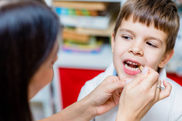 istock Cute preschool child is engaged in speech therapist office and correcting his speech 1352831917