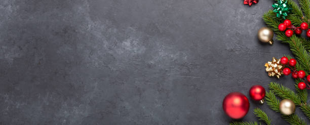 istock Horizontal banner with fir tree and red decoration on dark stone background. Top view Copy space 1352832040
