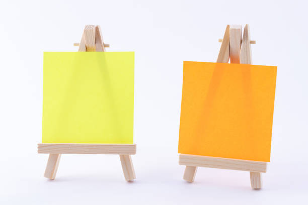 istock Two Wooden Easels Miniature with Blank Colored Square Canvas or Memo Paper 1352833409