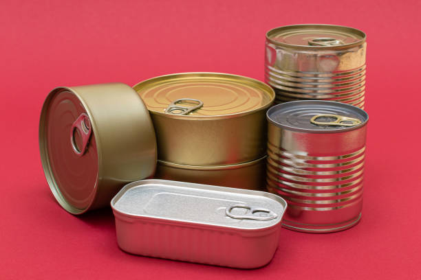 istock Unopened Tin Cans with Blank Edges on Red Background 1352833456
