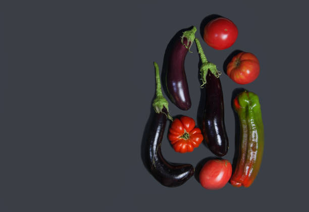 istock Creative layout of vegetables, peppers and eggplants with ribbed tomatoes on a dark background.Flat lay. The concept of nutrition.Creative layout of summer vegetables. vegetarianism. ajapsandal recipe 1352833799