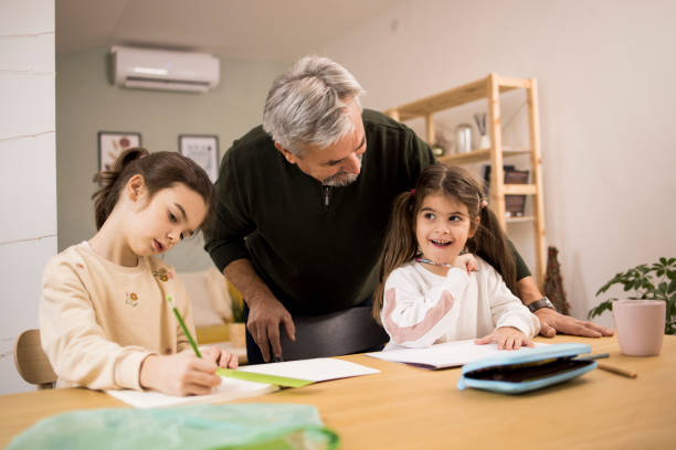 istock Senior man homeschooling his two little granddaughters 1352834473