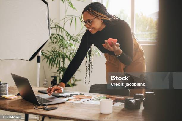 Freelancer Taking A Phone Call While Working Stock Photo - Download Image Now - Self-Employment, Women, One Woman Only