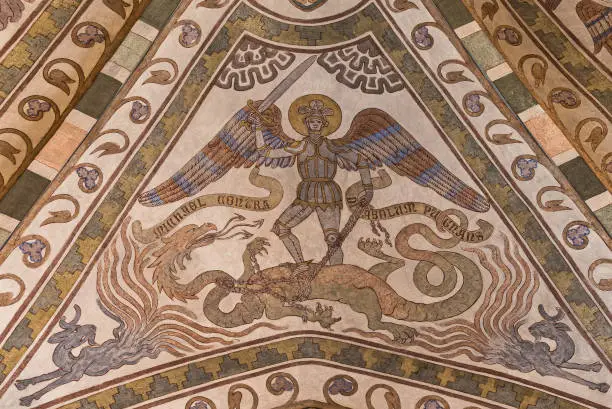 the archangel Michael in armour lifts his sword and kills the dragon, a 800 years old fresco by an unknown artist from the 1300s in St. Köpinge church, Sweden, free of copyright protection, July 16, 2021