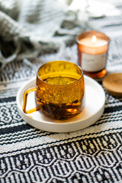 istock Cup of tea and cozy burning candle on white tray 1352840558
