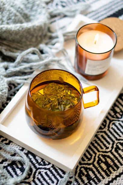istock Cup of tea and cozy burning candle on white tray 1352840641