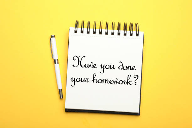 istock Pen and stylish notebook with phrase HAVE YOU DONE YOUR HOMEWORK? on yellow background, top view 1352840666