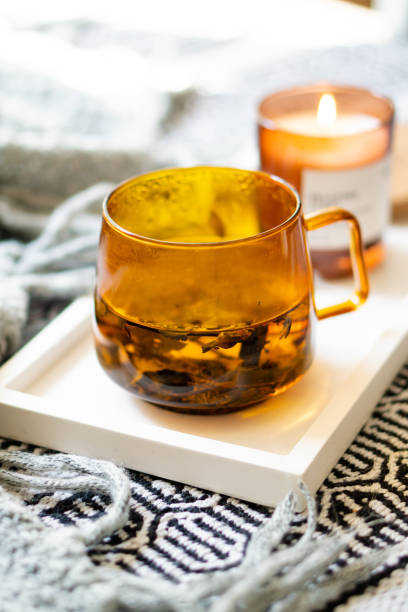 istock Cup of tea and cozy burning candle on white tray 1352840673
