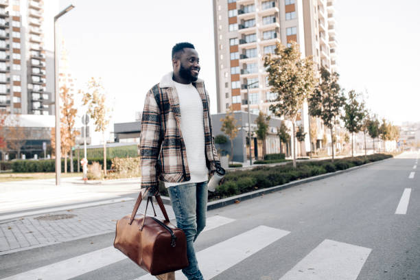 istock African American walking through the city and drinking coffee 1352847100