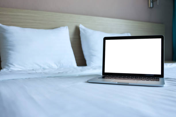 istock Mock up Blank screen laptop on the bed for advertising and text. 1352847185