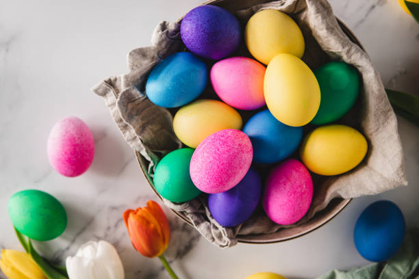 istock Colorful Easter eggs in basket with flowers on table 1352847922