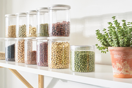 On the bright indoor kitchen shelves, neatly arranged glass jars are filled with various beans and whole grains. These healthy foods can reduce fat and calories, and provide a lot of fiber and vitamins. It is a good edible material for fitness and weight loss.
