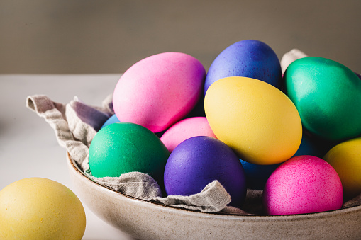Close-up of multicolored Easter eggs in bowl on a table. Decorated eggs in a bowl for Easter holiday.