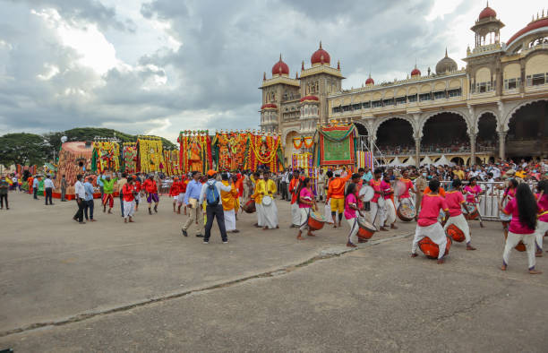 un gruppo di processione di performance composto da banda musicale, ballerini, divinità con costumi vivaci per il carnevale dasara a mysore palace, in india. - mysore foto e immagini stock