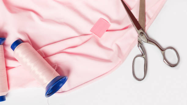 istock Tailoring. sewing accessories. pink fabric. threads scissors, on a white background close-up 1352848680