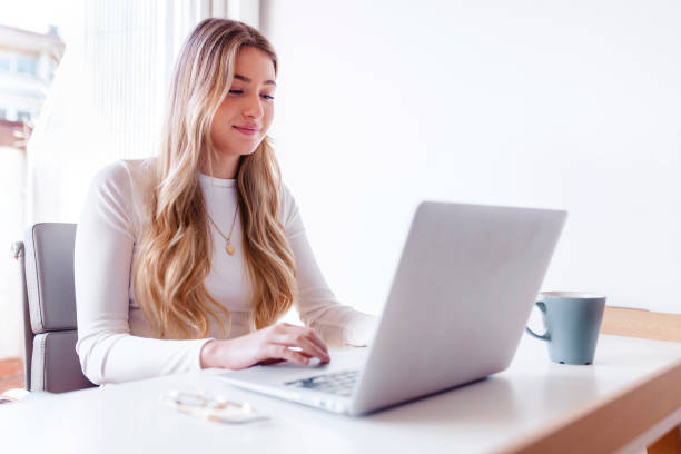 Free Stock Photo of A young blonde woman working on her laptop ...
