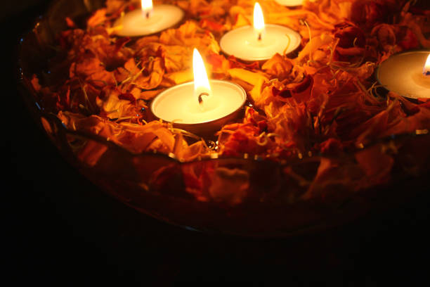 istock Burning Tea light candles and fresh marigold flower petals 1352851837
