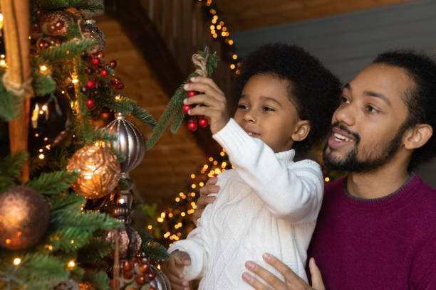 istock Happy biracial dad and small son decorate Christmas tree together 1352853533