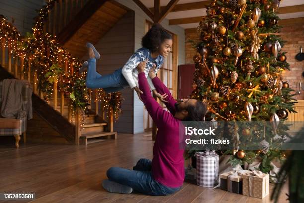 Playful Biracial Father Have Fun With Small Daughter At Home Stock Photo - Download Image Now