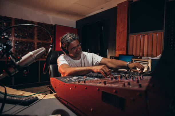 istock Senior hispanic music producer working on a mixing soundboard while in his studio 1352853677