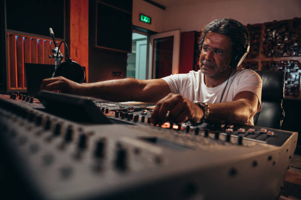 istock Senior hispanic music producer working on a mixing soundboard while in his studio 1352853679