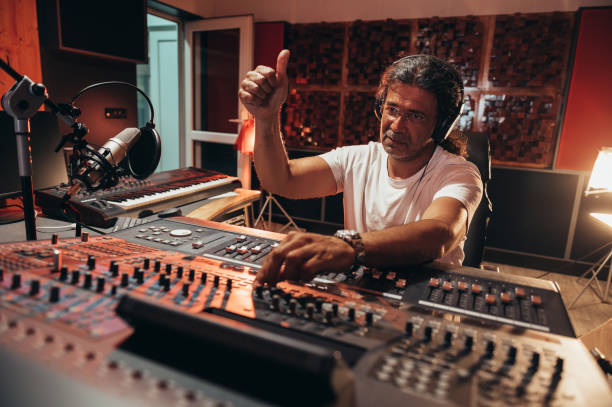 istock Senior hispanic music producer working on a mixing soundboard while in his studio 1352853684