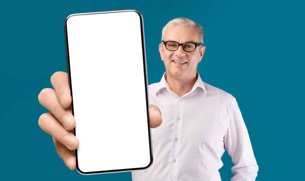 istock Great App. Smiling Senior Man Showing Smartphone With Blank Screen At Camera 1352856601