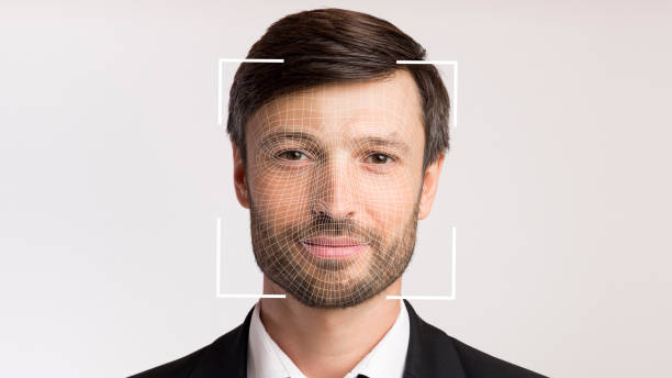 istock Friendly millennial businessman with stubble in suit scanning for facial recognition 1352856830