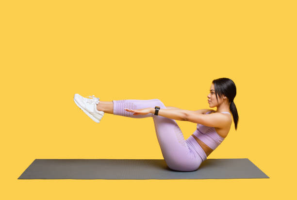 istock Athletic african american woman doing abs exercises during her workout, sitting on mat over yellow background 1352856841