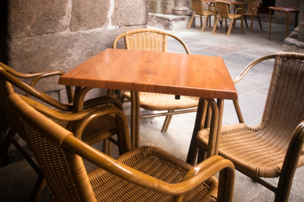 Close-up view of empty sidewalk cafe,  chairs and table, narrow city street, pedestrian zone.  Santiago de Compostela old town, Galicia, Spain